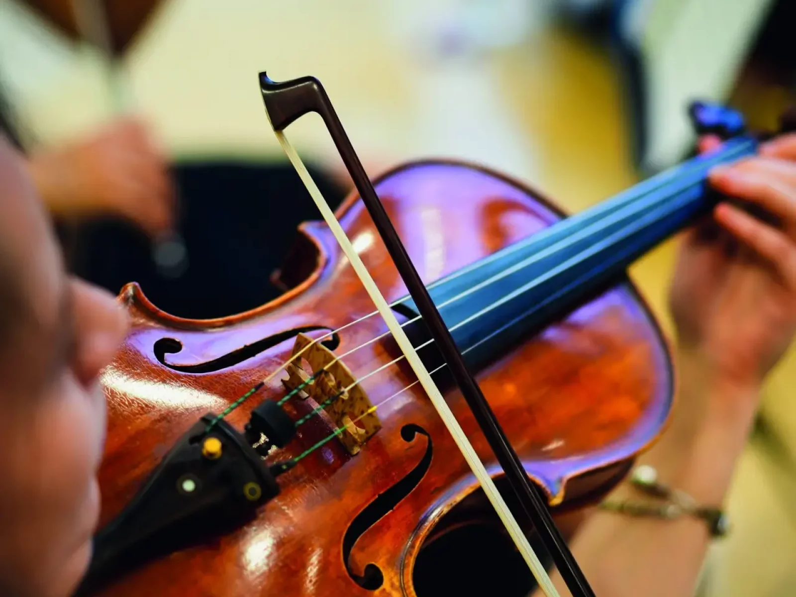Detail view of an unrecognizable woman playing the violin in public.